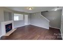 View of the living room with a fireplace and wood-look floors, creating a cozy ambiance at 8403 Spirea Ct, Charlotte, NC 28215