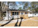 View of the white brick ranch showcasing the front porch and a concrete pathway and lawn at 919 N Weldon St, Gastonia, NC 28052
