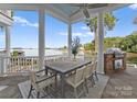 Outdoor dining area on porch features a stone floor, a grill and lake views at 16921 Jetton Rd, Cornelius, NC 28031