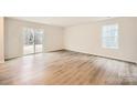 Bright living room featuring hardwood floors, white walls, and sliding door to the backyard at 110 Dorian Pl, Troutman, NC 28166