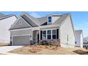 Charming single-Gathering home features a two-car garage and stone accents, set against a bright, sunny sky at 5096 Silver Creek Ln, Denver, NC 28037