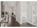 Elegant hallway with dark wood floors, white wainscoting and views into the living room and bedroom at 5096 Silver Creek Ln, Denver, NC 28037