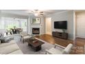 Bright living room featuring a fireplace, hardwood floors, and comfortable seating near the open dining area at 5832 Amity Springs Dr, Charlotte, NC 28212