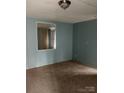 A basic bedroom featuring blue paneled walls, neutral carpeting, and a glimpse of an interior door at 1926 Scenic Dr, Iron Station, NC 28080