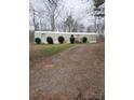 Cozy mobile home featuring a gravel driveway and small front yard landscaping with decorative bushes at 1926 Scenic Dr, Iron Station, NC 28080