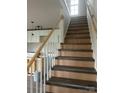 Interior view of a new home showing the stairway with wood and gray steps and white spindles at 1506 7Th St, Statesville, NC 28677