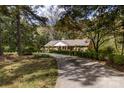 Long driveway leading to a charming brick home surrounded by lush trees providing a secluded feel at 5444 Marengo Cir, Charlotte, NC 28216