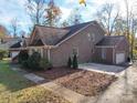 Two-story brick house featuring an attached two-car garage and large driveway at 909 Woodhurst Dr, Monroe, NC 28110