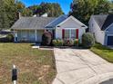 Tan house with red shutters, landscaping, and driveway at 14301 Beryl Ct, Pineville, NC 28134