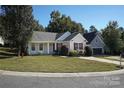 Tan house with red shutters, landscaping, and driveway at 14301 Beryl Ct, Pineville, NC 28134