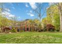 Stately two-story brick home featuring manicured lawn and mature trees at 9723 Sedgefield Dr, Waxhaw, NC 28173