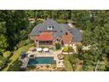 Backyard aerial view with a swimming pool, patio, lounge chairs, and lush landscaping at 9723 Sedgefield Dr, Waxhaw, NC 28173