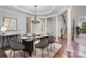 Elegant dining room featuring a chandelier, decorative columns, and a glass-topped table with seating for eight at 1001 Hatton Ter, Fort Mill, SC 29707