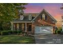 Brick home with a two-car garage, landscaping, and a sunset view at 1001 Hatton Ter, Fort Mill, SC 29707