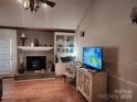 Living room with brick fireplace, built-in shelving, and hardwood flooring at 2015 Pine Needle Ct, Gastonia, NC 28056