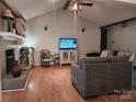 Cozy living room with hardwood floors, fireplace, and entertainment center at 2015 Pine Needle Ct, Gastonia, NC 28056