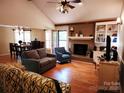 Inviting living room with a brick fireplace, hardwood floors, and an adjacent dining area at 2015 Pine Needle Ct, Gastonia, NC 28056
