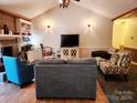 Cozy living room featuring a brick fireplace, built-in shelving, and stylish seating arrangements at 2015 Pine Needle Ct, Gastonia, NC 28056