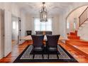 Bright dining room with modern chandelier, statement rug, and doorway to stairwell at 501 River Oaks Ln, Charlotte, NC 28226