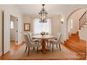 Cozy dining room with warm hardwood floors, chandelier, and an adjacent staircase at 501 River Oaks Ln, Charlotte, NC 28226