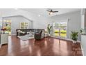 Bright living room with beautiful wood floors, large windows, and a comfortable sectional sofa at 3157 Delaware Dr, Denver, NC 28037