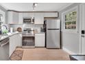 Well-lit kitchen featuring stainless steel appliances, white cabinets, and tile flooring at 508 Deese St, Monroe, NC 28112