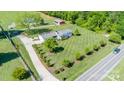 Aerial view of a well-maintained property featuring a single-story home with manicured lawns and a long driveway at 796 Cornelius Rd, Mooresville, NC 28117