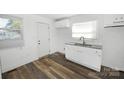 Bright kitchen boasts white cabinets, granite countertops, and stylish flooring at 125 S Ervin Ave, Newton, NC 28658