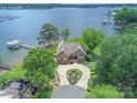 Aerial view showcasing the waterfront property with private dock, lush landscaping, and expansive lake at 18212 Pompano Pl, Cornelius, NC 28031