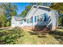 A light blue house is pictured with bright blue shutters with a well maintained lawn at 5039 Penn Rd, Iron Station, NC 28080