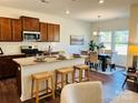 Modern kitchen with granite countertops, stainless steel appliances, a breakfast bar, and an adjacent dining area at 1032 Bull Dog Ln, Wingate, NC 28174