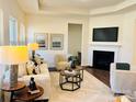 Bright living room featuring a fireplace, tray ceiling, neutral decor, and ample natural light at 1032 Bull Dog Ln, Wingate, NC 28174