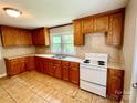 Simple kitchen with wood cabinets and white appliances at 503 Broad St, Kings Mountain, NC 28086