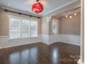 Bright dining area featuring wainscoting, gleaming hardwood floors, and modern light fixture at 507 Quicksilver Trl, Fort Mill, SC 29708