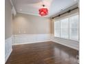 Elegant dining room boasts hardwood floors, wainscoting, large windows, and modern lighting at 507 Quicksilver Trl, Fort Mill, SC 29708