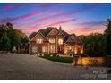 Stately brick home with manicured lawn and illuminated driveway, showcasing elegance at 2723 Providence Pine Ln, Charlotte, NC 28270