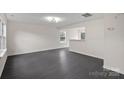 Living room with dark gray vinyl flooring and a view into the kitchen at 2807 Station Sw Ln, Concord, NC 28025