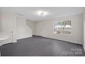 Bright living room with gray flooring and a view of a front yard at 2807 Station Sw Ln, Concord, NC 28025