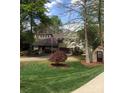 Traditional home featuring mature landscaping, a two car garage, and an American flag at 377 Riverwood Rd, Mooresville, NC 28117