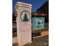Brick entrance sign for Pine Trace Neighborhood featuring a green tree emblem and wooden accents at 4049 Port Richmond Ave # 11, Gastonia, NC 28056