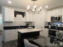 Kitchen area with white cabinetry, a black countertop, and an island with a marble top at 4986 6Th Sw St, Catawba, NC 28609