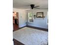 Bright living room featuring hardwood floors, white trim, and a ceiling fan with light fixture at 7608 Kershaw Camden Hwy, Kershaw, SC 29067
