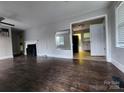 Cozy living room featuring a decorative fireplace, light walls, and worn hardwood floors at 3337 Eastway Dr, Charlotte, NC 28205