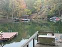 Scenic lake view with multiple docks, boats, and lush trees during the autumn season at 26034 Misty Way Dr, Fort Mill, SC 29708