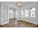 Bright living room features hardwood floors, white walls, French doors, and a modern chandelier at 714 Barrel Aly, Fort Mill, SC 29715