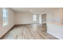 Bright living room featuring modern wood floors, neutral walls, and large windows that provide plenty of natural light at 117 Dorian Pl, Troutman, NC 28166