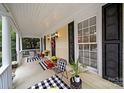 Relaxing front porch with black and white checkered decor, potted plants and fall decor at 1360 Barnett Woods, Fort Mill, SC 29708