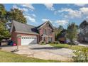 Beautiful brick home exterior featuring an attached garage, neat landscaping, and a wide driveway for ample parking space at 1136 Preakness Nw Ct, Concord, NC 28027