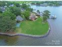 Beautiful lakefront home with a well-manicured lawn, boat dock, and mature trees at 18210 Pompano Pl, Cornelius, NC 28031