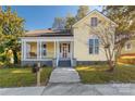 Charming yellow house with front porch and steps at 305 N White St, Lancaster, SC 29720